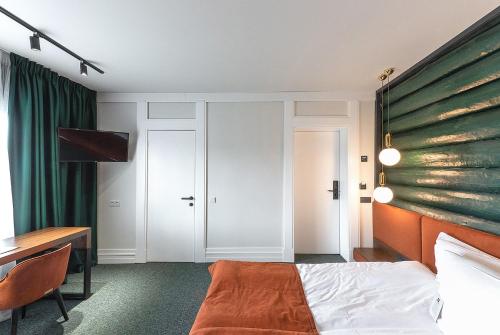 a bedroom with a bed and a desk and a table at Stara Pravda Hotel in Bukovel