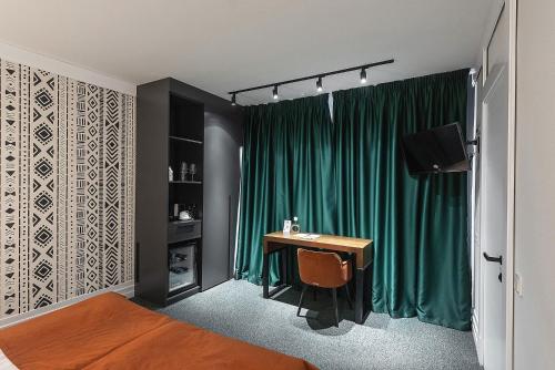 a bedroom with a desk and a green curtain at Stara Pravda Hotel in Bukovel