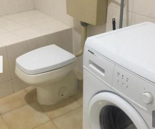 ein Badezimmer mit einem WC und einer Waschmaschine in der Unterkunft ESTUDIO VILA PRAIA DE ÂNCORA in Vila Praia de Âncora