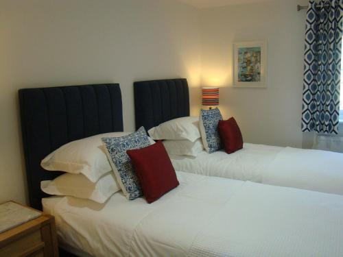 two beds sitting next to each other in a bedroom at Topsail, Falmouth in Falmouth