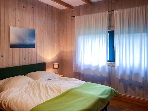 a bedroom with a bed and a window with a curtain at CHATA POD SOSNĄ in Czaszyn