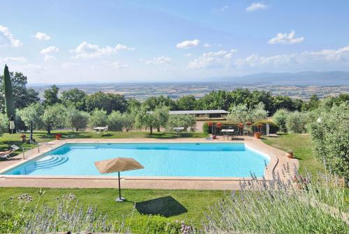 a swimming pool in a garden with a view at Agriturismo I Frati in Paciano