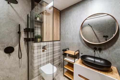een badkamer met een zwarte wastafel en een spiegel bij Apartament Rentes 15 Szczyrk in Szczyrk