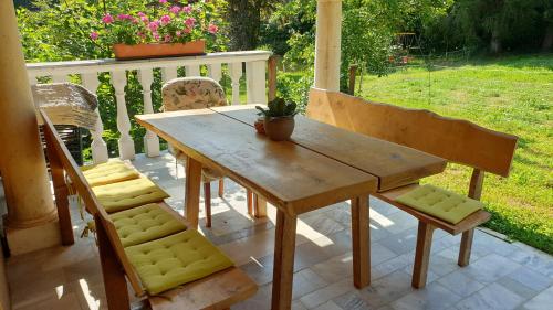 einen Holztisch und zwei Stühle auf einer Veranda in der Unterkunft Ferienwohnungen Gut Seebacher in Klagenfurt am Wörthersee