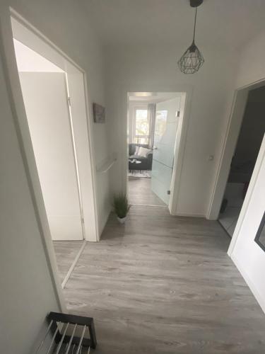 an empty hallway with white walls and a hallway with a door at Apartment Am Grünen Park in Erfurt