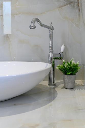 a bathroom with a sink and a faucet at Dionisos Suites in Lixouri