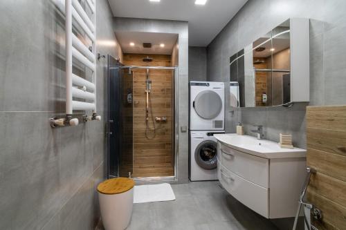 uma casa de banho com um lavatório e uma máquina de lavar roupa em 7 Senses Luxury Apartment em Gudauri