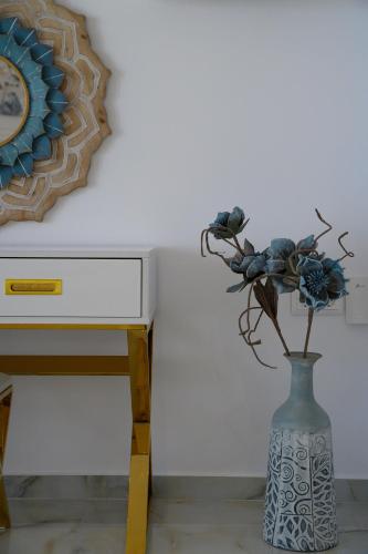 a vase with flowers in it next to a desk at Dionisos Suites in Lixouri
