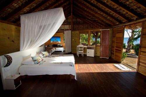 a bedroom with two beds in a room with a kitchen at Anjiamarango Beach Resort in Nosy Be