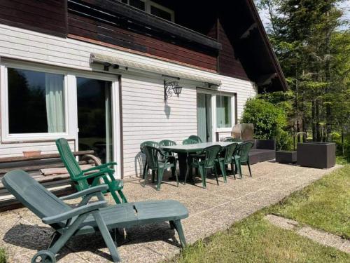 a patio with a table and chairs on the side of a house at Ferienhaus Roman in Hinterstoder