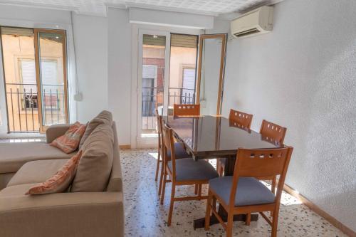 a living room with a couch and a table and chairs at Teniente Ruiz 27 in Elche