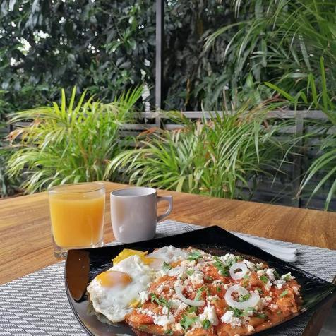 a plate of food with eggs and a glass of orange juice at Nardazul "Casa de Sueños" in Oaxaca City