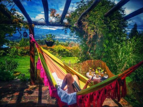 two people laying in a hammock with a table in at The Naked House - Hotel Nudista in Nemocón