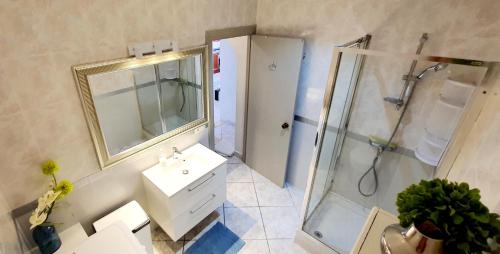 La salle de bains est pourvue d'une douche, d'un lavabo et d'un miroir. dans l'établissement EL Gecko, à Alcossebre