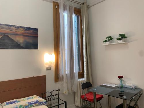 una camera con letto, tavolo e finestra di Archie's House a Venezia