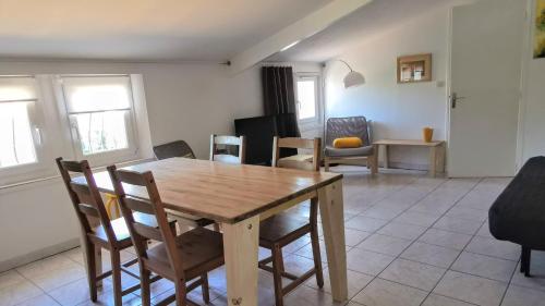 une salle à manger avec une table et des chaises en bois dans l'établissement Au clair de la Dune, à Saint-Cyr-sur-Mer