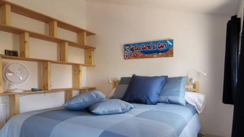 une chambre avec un lit avec des oreillers bleus dans l'établissement Au clair de la Dune, à Saint-Cyr-sur-Mer