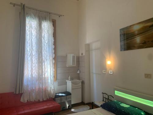 a living room with a window and a red couch at Archie's House in Venice