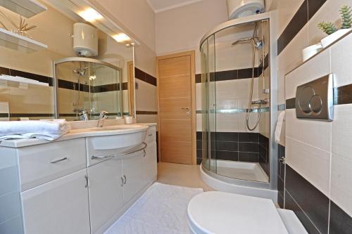a bathroom with a shower and a sink and a toilet at Apartments Villa Violet in Zadar