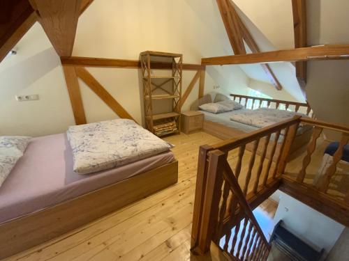 two beds in a attic room with wooden floors at Bungalow Smiltele in Nida