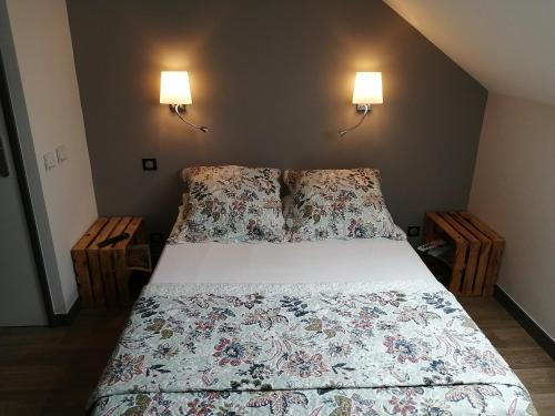 a bed in a bedroom with two lamps on the wall at Le Grand Chatelard HÔTEL BAR RESTAURANT in Sainte-Marie-de-Cuines