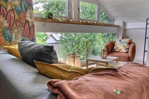 a room with a couch with pillows and a window at Lî Gurni in Houffalize
