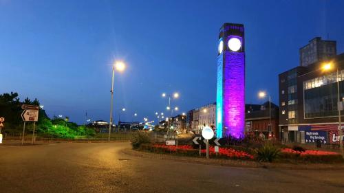 a tall clock tower with a purple light on it at Gabriel Guesthouse in Rhyl