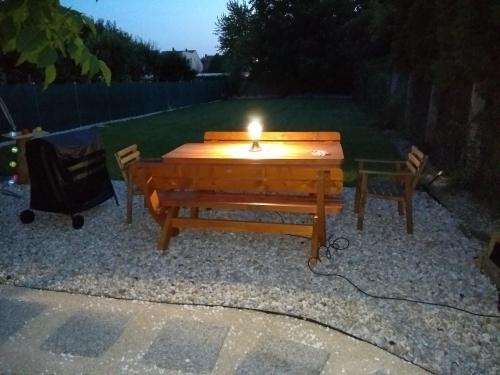 a candle sitting on a picnic table with two chairs at Jade Vendégház in Pápa