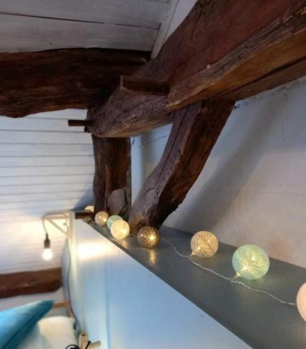a ceiling with wooden beams and balls on a shelf at Lî Gurni in Houffalize