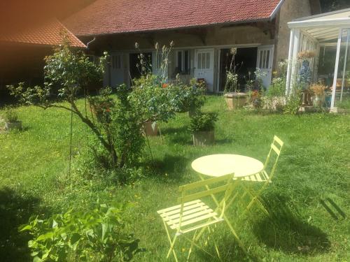 - une table et des chaises dans la cour d'une maison dans l'établissement Le Refuge private entrance 2/4 pers dans maison 17eme siècle.Parking. calme, à Autrêches