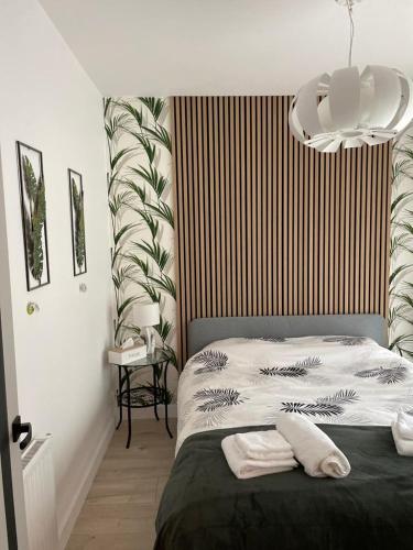 a bedroom with a bed and a chandelier at Zielone Rozewie Park in Rozewie