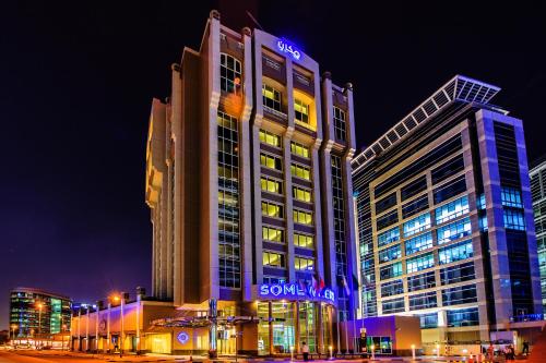 a large building with a sign on it at night at Somewhere Hotel Apartment in Dubai