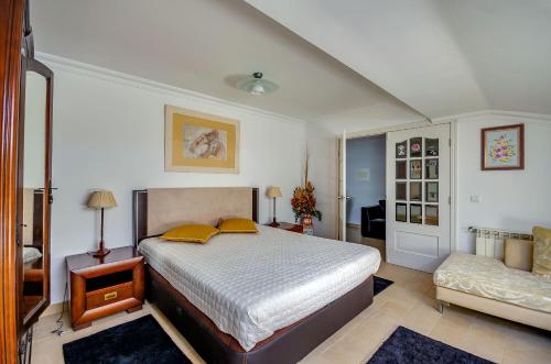 1 dormitorio con cama con almohadas amarillas y sofá en Apartamentos 7 saias, en Nazaré