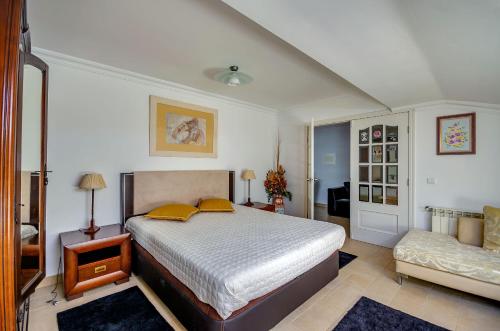a bedroom with a bed with yellow pillows and a couch at Apartamentos 7 saias in Nazaré