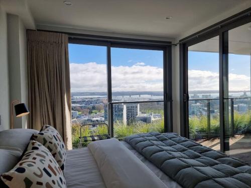 a living room with a couch and a large window at Union Green Apt w Stunning Views - Free Parking in Auckland
