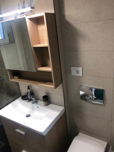 a bathroom with a sink and a toilet and a mirror at Sunrise in Alba Iulia