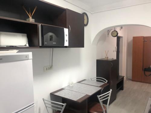 cocina y comedor con mesa y microondas en Sunrise, en Alba Iulia