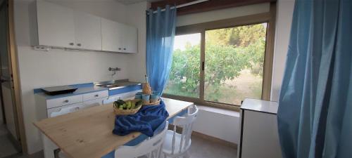 eine kleine Küche mit einem Tisch und einem Fenster in der Unterkunft Casa tra Cielo e Mare in Lipari