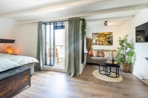 - une chambre avec un lit et un canapé dans l'établissement Zandvoort-17, à Zandvoort