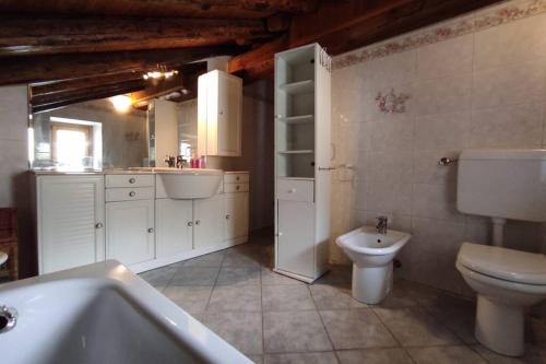 łazienka z toaletą, umywalką i wanną w obiekcie Casa vacanze Monica ' s house w mieście Saint-Pierre