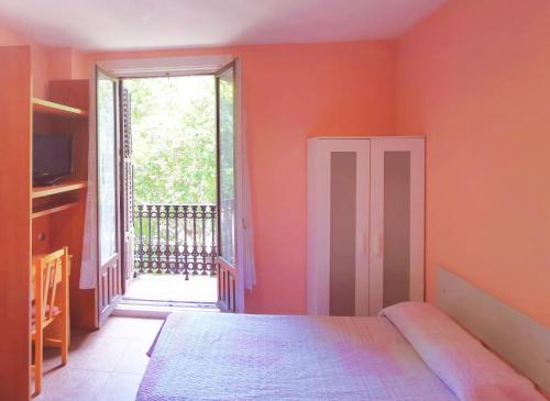 a bedroom with a bed and a large window at Casa de Huespedes La Asturiana in Madrid