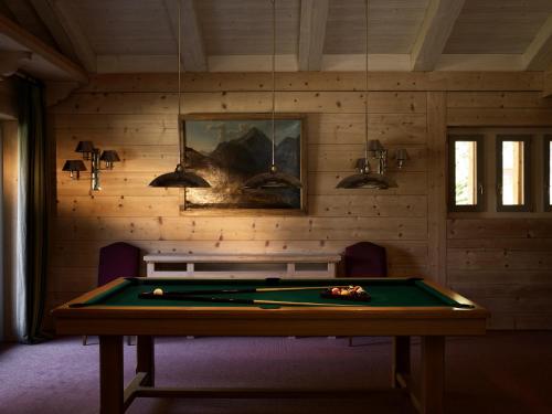 a ping pong table in a room with a pool at LeCrans in Crans-Montana