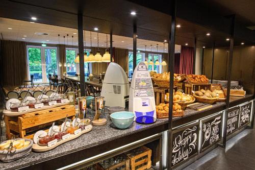 a buffet line with various types of bread and pastries at Holiday Inn Lübeck by IHG in Lübeck