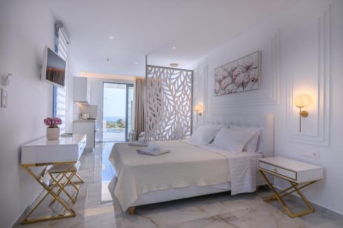 a white bedroom with a bed and a desk at Dionisos Suites in Lixouri