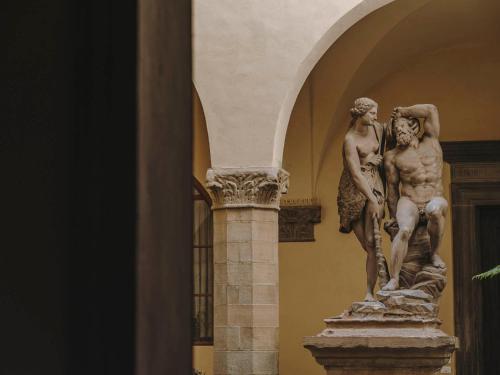 une statue de deux hommes sur une colonne dans un bâtiment dans l'établissement Numeroventi Design Residency, à Florence