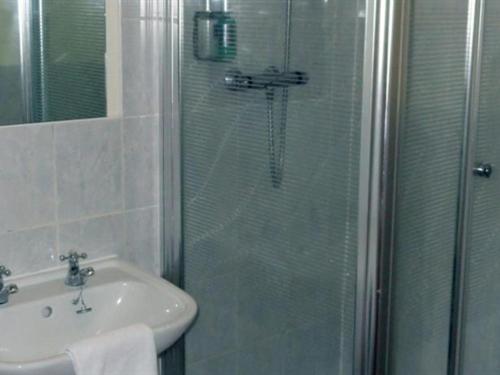 a bathroom with a glass shower and a sink at The William IV in Norwich