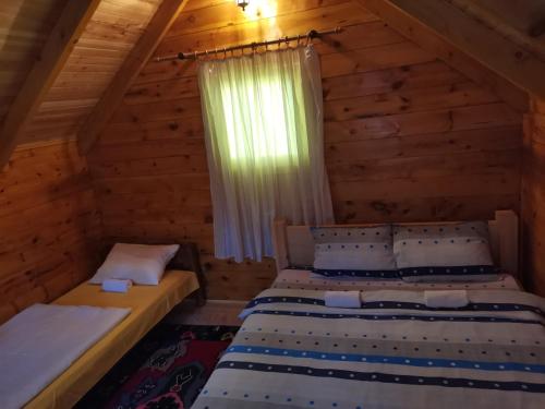 sypialnia z 2 łóżkami w drewnianym domku w obiekcie Gazela Bungalov 2 w mieście Mojkovac