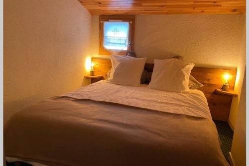 1 dormitorio con 1 cama blanca y ventana en Appartement duplex Belle Plagne, en La Plagne