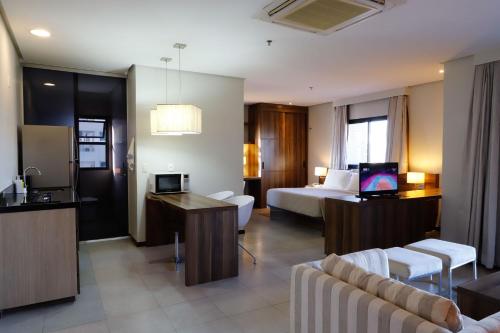um quarto de hotel com uma cama e uma sala de estar em Sofisticado Loft Mobiliado no Coração do Umarizal em Belém