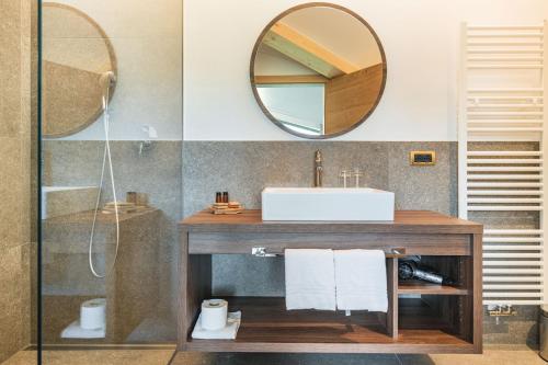 a bathroom with a sink and a mirror at Garni Hotel Miara - Your Dolomites Home in Selva di Val Gardena